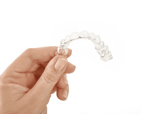 A picture of a clear aligner held in the air